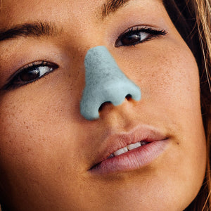 Close up of girls face with blue NÖZ sunscreen on nose